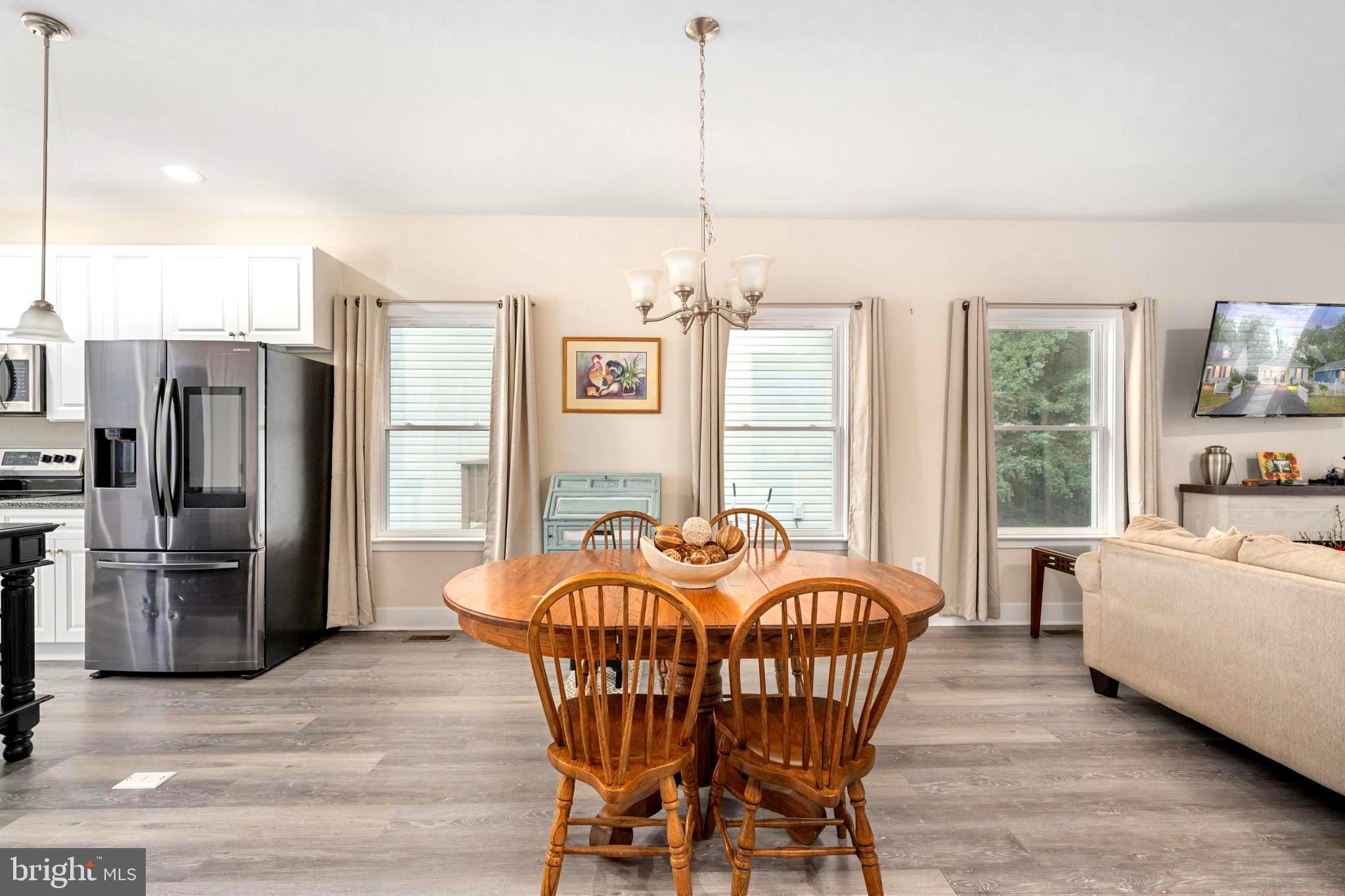 137 12th Street Colonial Beach, VA 22443 - Photo 29 of 66 a dining room with furniture a chandelier and wooden floor