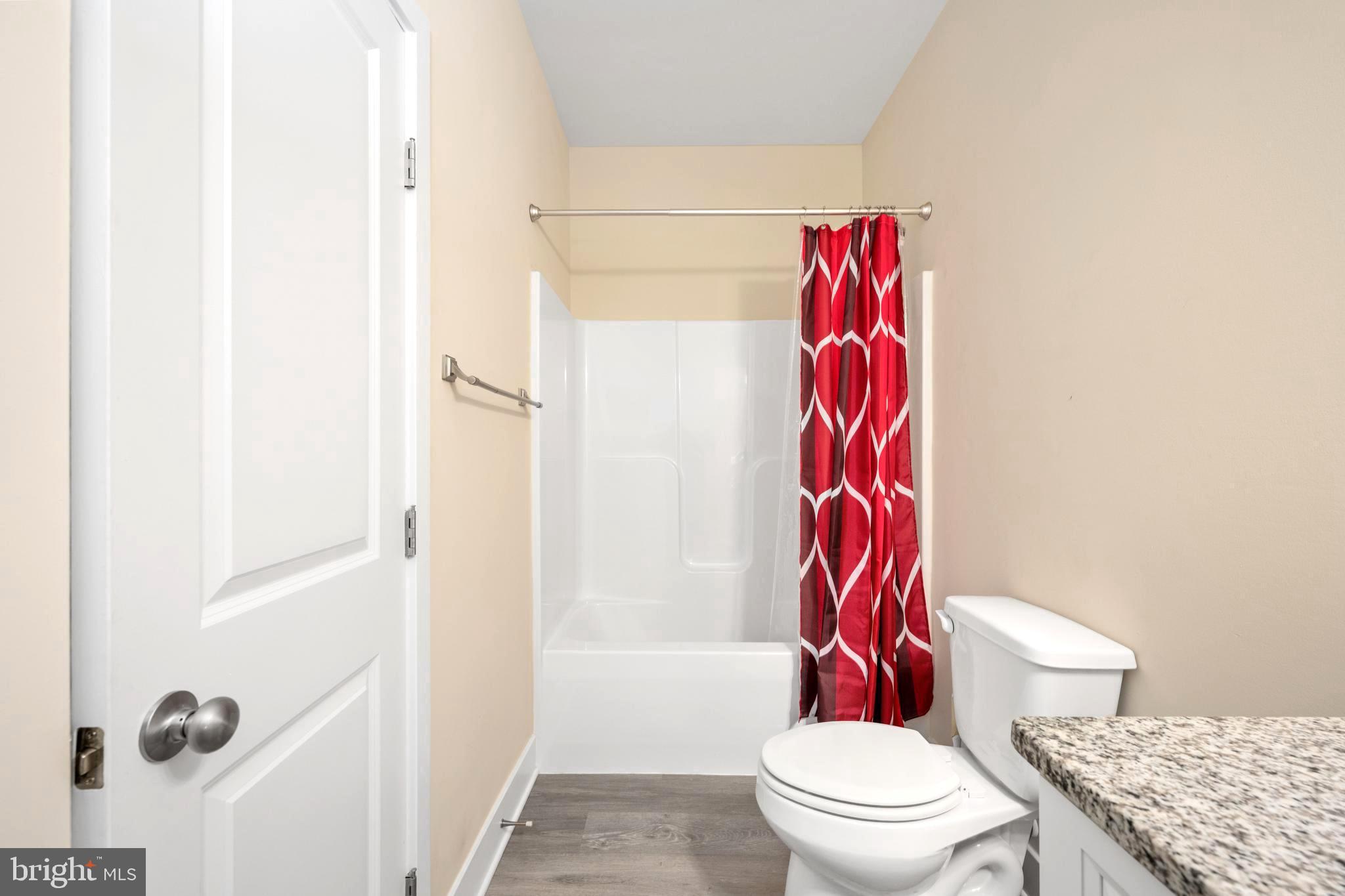 137 12th Street Colonial Beach, VA 22443 - Photo 42 of 66 a bathroom with a toilet and a shower curtain