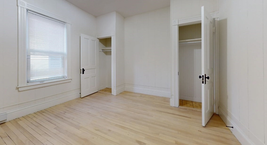 18 Elizabeth Street Worcester, MA 01605 - Photo 6 of 13 an empty room with wooden floor closet and windows