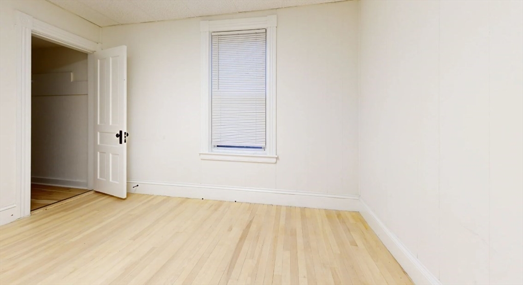 18 Elizabeth Street Worcester, MA 01605 - Photo 7 of 13 an empty room with wooden floor and a window