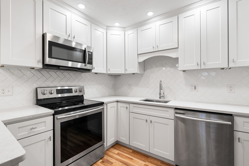 a kitchen with white cabinets and stainless steel appliances