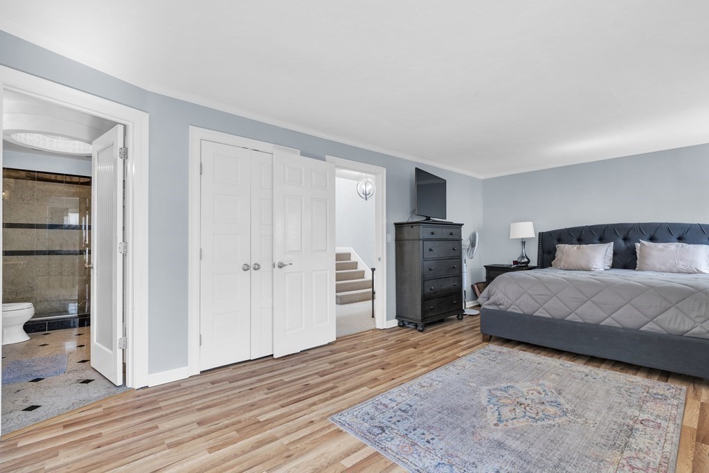 166 Quincy Shore Drive, Unit 108 Quincy, MA 02171 - Photo 11 of 36 a bedroom with a bed and wooden floor