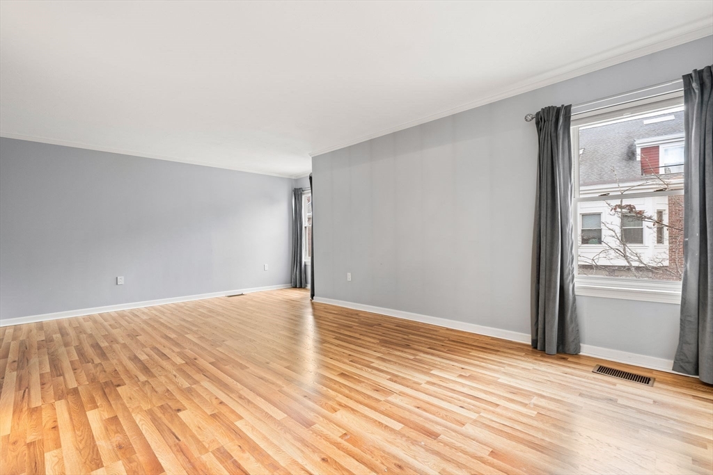 166 Quincy Shore Drive, Unit 108 Quincy, MA 02171 - Photo 13 of 36 a view of an empty room with wooden floor and a window