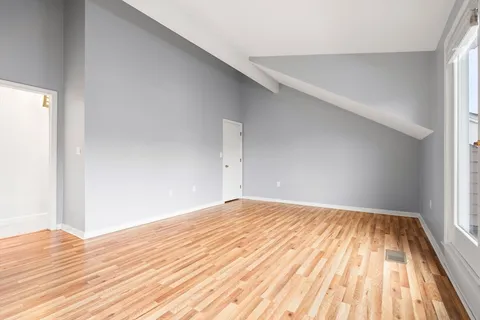 a view of empty room with wooden floor