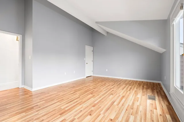 a view of empty room with wooden floor
