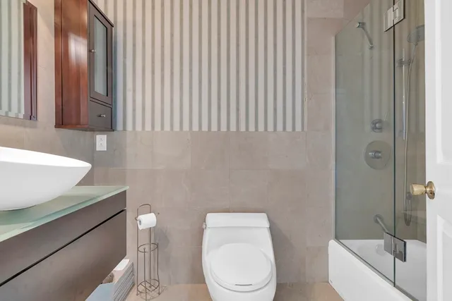 a white toilet sitting next to a bathroom sink