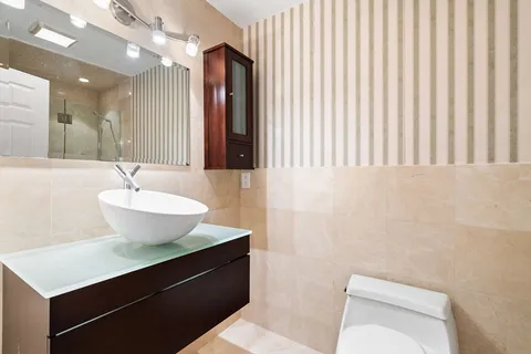 a bathroom with a sink a toilet and mirror