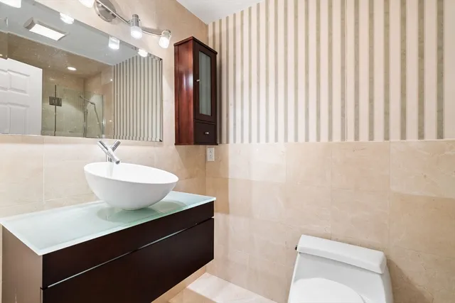 a bathroom with a sink a toilet and mirror