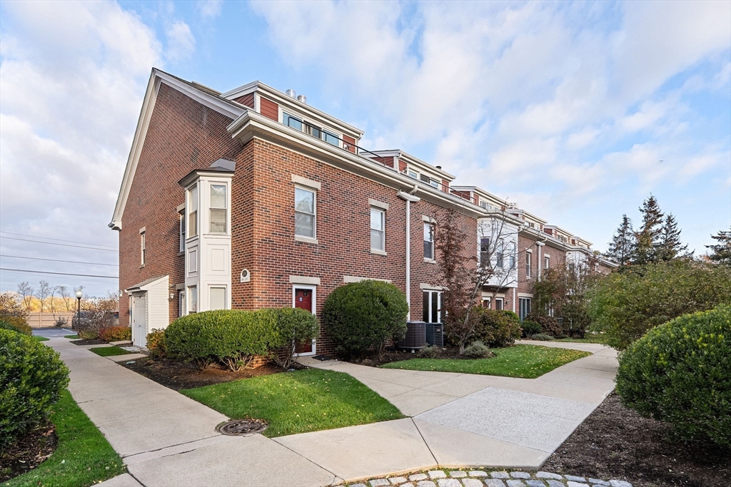 166 Quincy Shore Drive, Unit 108 Quincy, MA 02171 - Photo 33 of 36 a front view of a house with yard and green space
