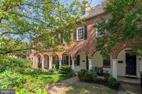 a view of a white house with large windows and a small yard