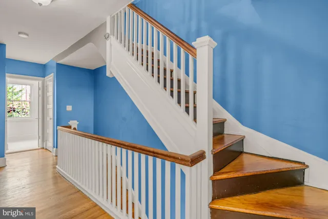 a view of staircase with railing and white walls