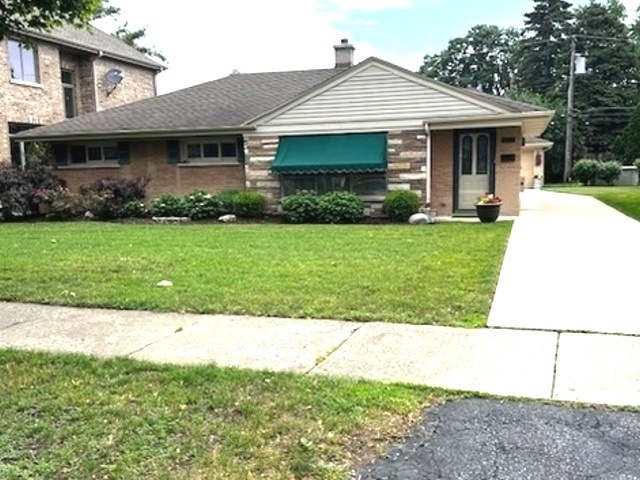 a front view of a house with a garden and plants