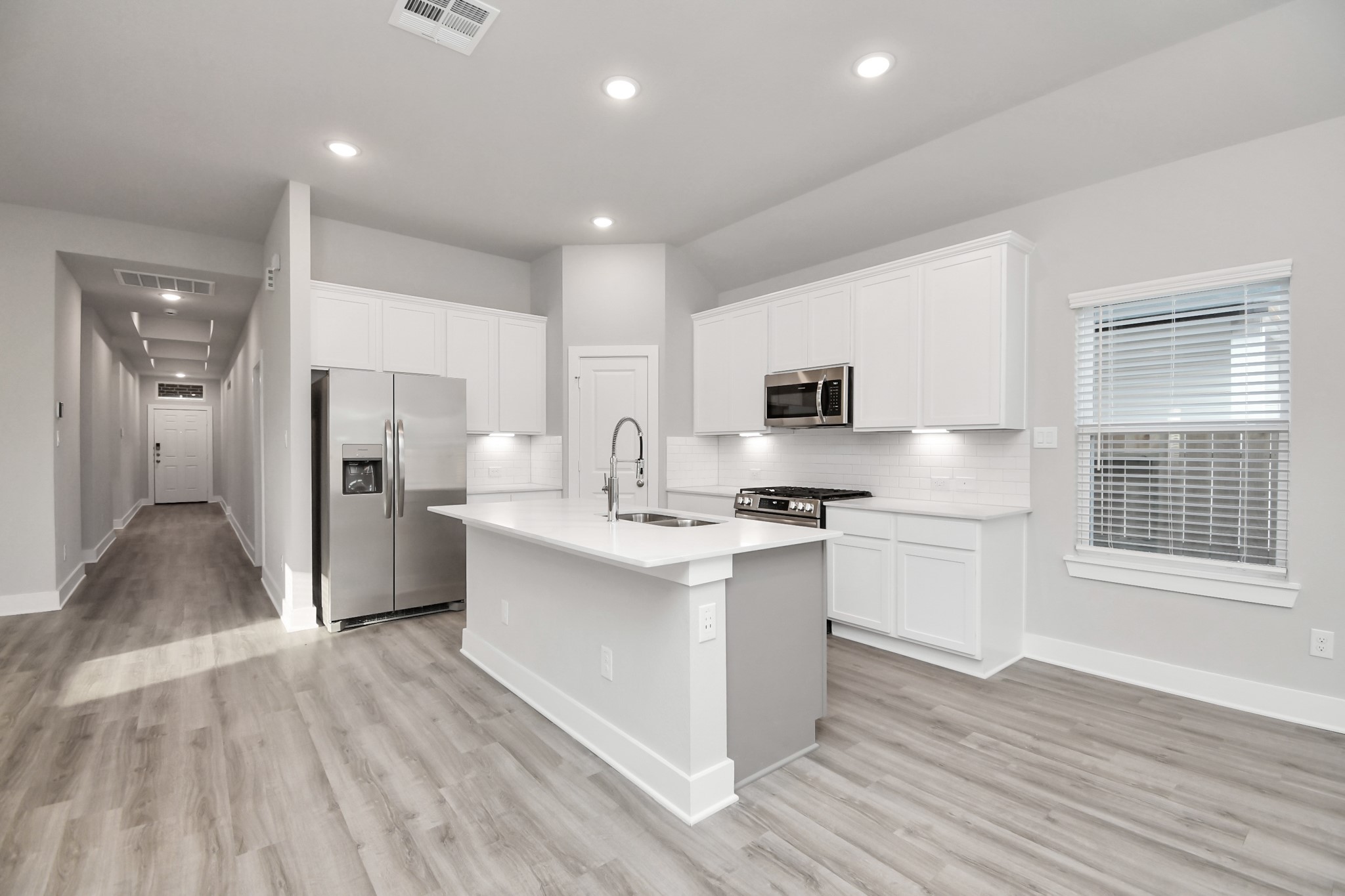 7510 Terramar Bay Lane Cypress, TX 77433 - Photo 4 of 20 a kitchen with stainless steel appliances white cabinets a sink a stove a refrigerator and a microwave