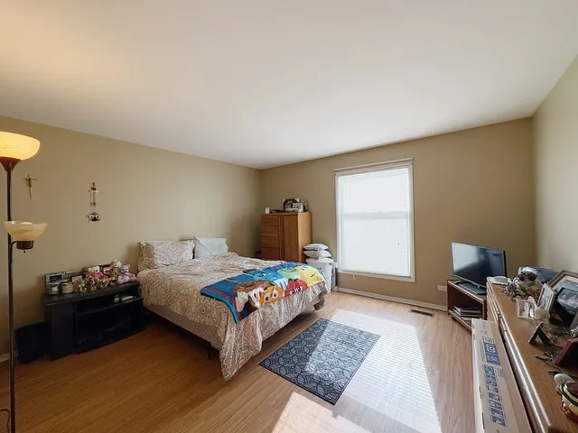 a bedroom with a bed and wooden floor