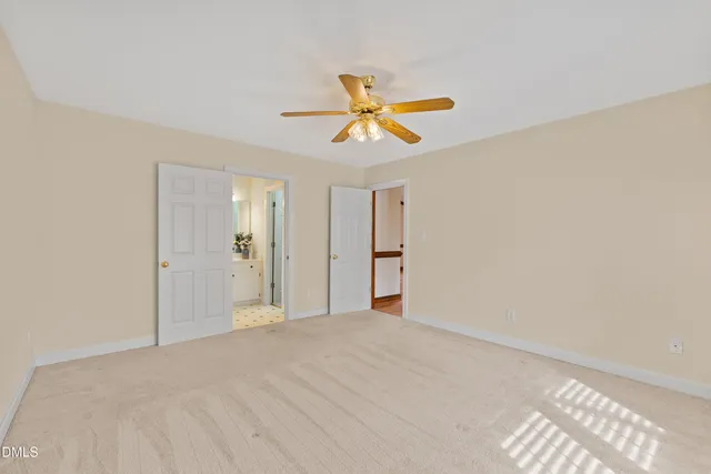 an empty room with a window and a ceiling fan