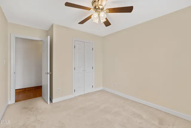 an empty room with windows and ceiling fan