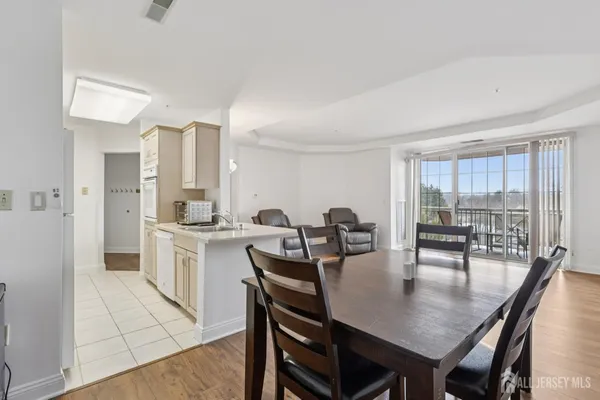 a kitchen with a dining table chairs and white appliances