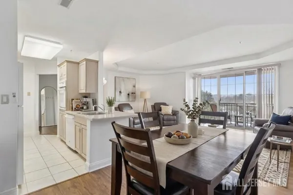 a view of a dining room and livingroom with furniture window and wooden floor
