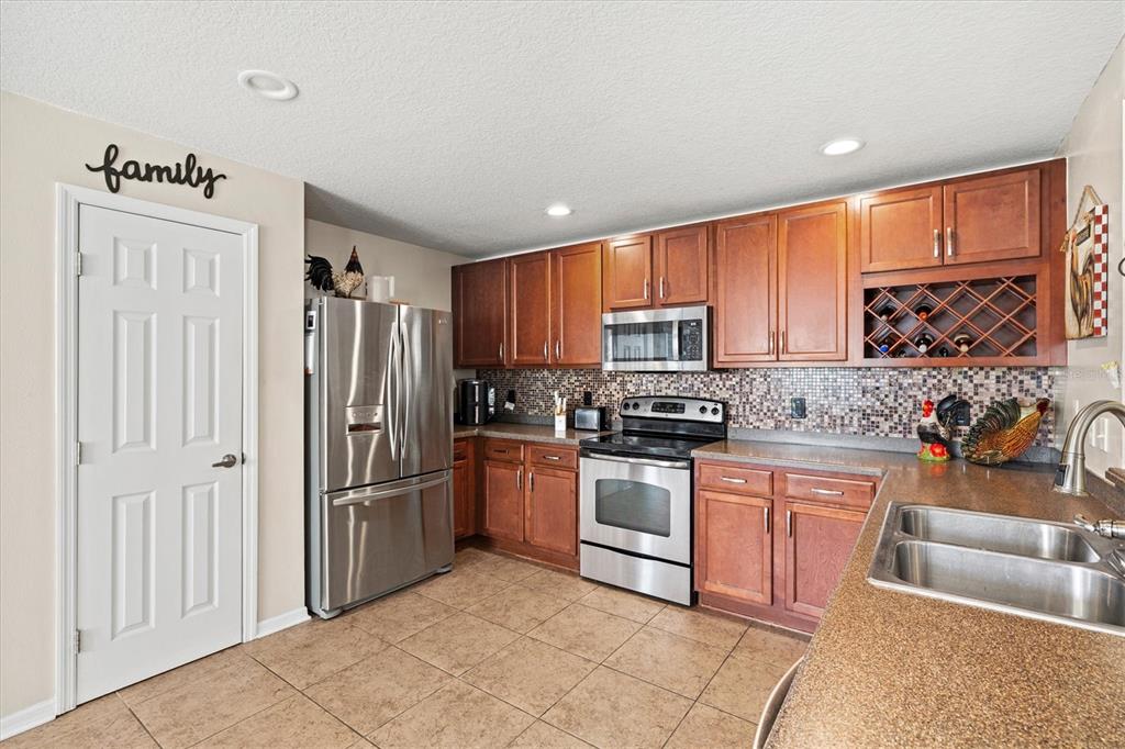 5213 Moon Shell Drive Apollo Beach, FL 33572 - Photo 15 of 69 a kitchen with stainless steel appliances granite countertop a refrigerator sink and cabinets