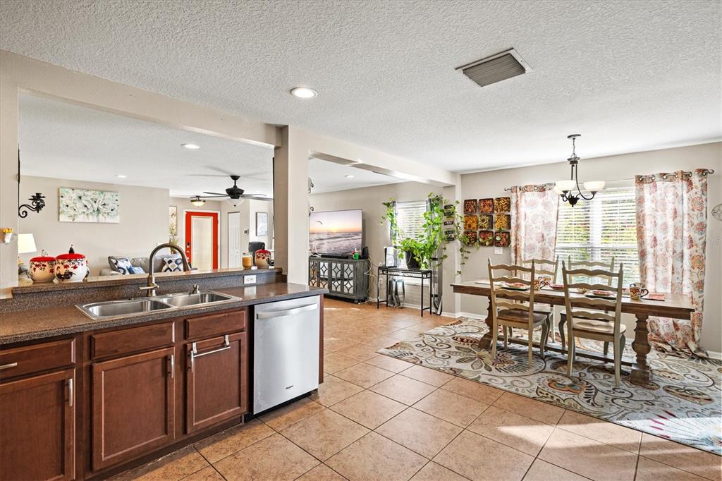 5213 Moon Shell Drive Apollo Beach, FL 33572 - Photo 18 of 69 a kitchen with stainless steel appliances granite countertop table chairs sink and cabinets