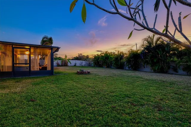 an aerial view of ocean and residential houses with outdoor space