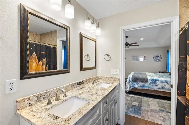 a bathroom with a granite countertop sink and a mirror