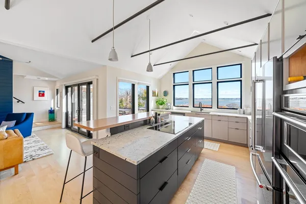 a living room with stainless steel appliances granite countertop a sink and a counter top space