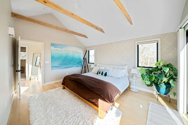 a bedroom with a bed lamp and a potted plant