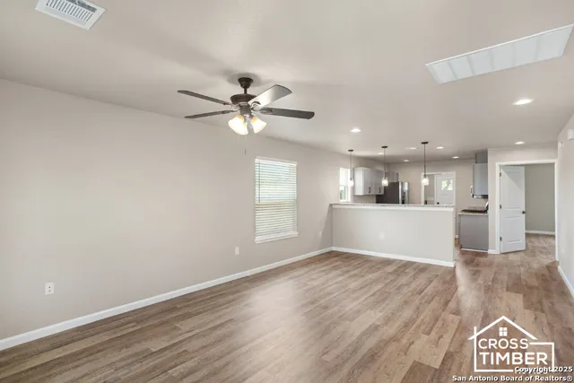 a view of an empty room with a kitchen