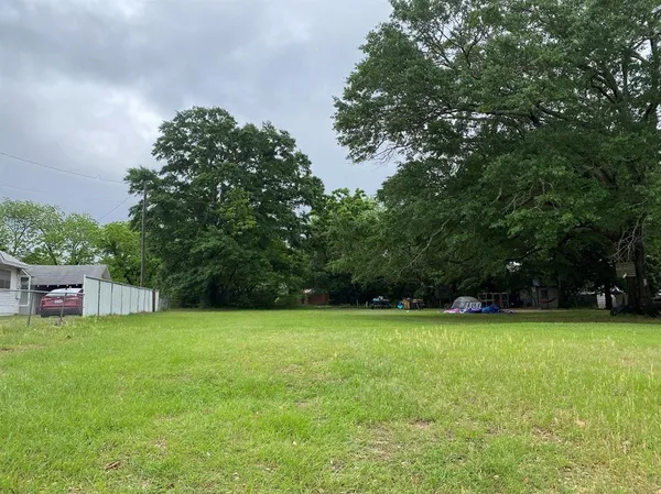 a view of a field with a trees in the background