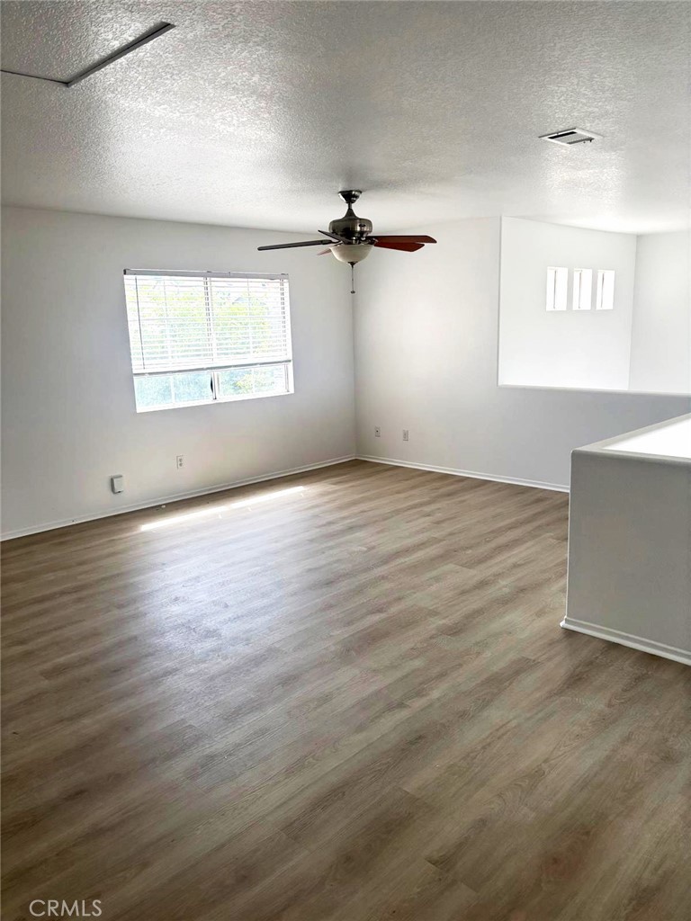 731 Raphael Circle Corona, CA 92882 - Photo 28 of 28 an empty room with wooden floor ceiling fan and windows