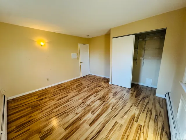 a view of a room with wooden floor and a bathroom