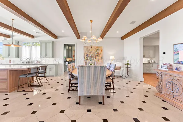 a kitchen with stainless steel appliances kitchen island granite countertop a refrigerator a stove and a sink with large cabinets