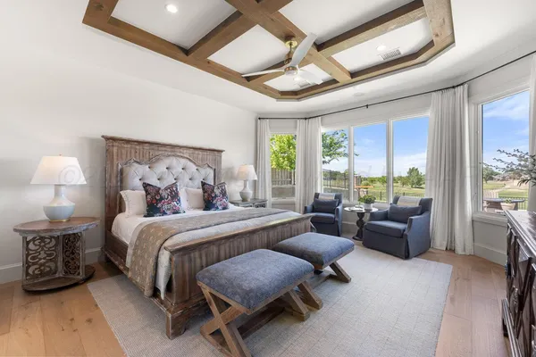a bedroom with a large bed and a chandelier