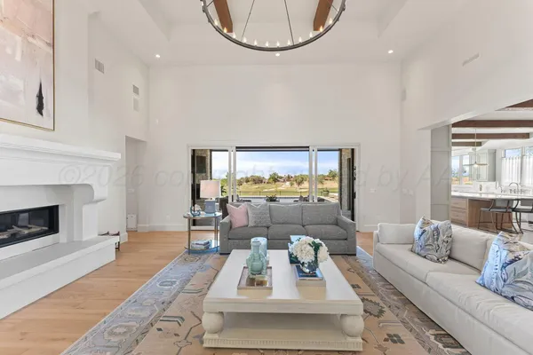 a living room with furniture a fireplace and a chandelier