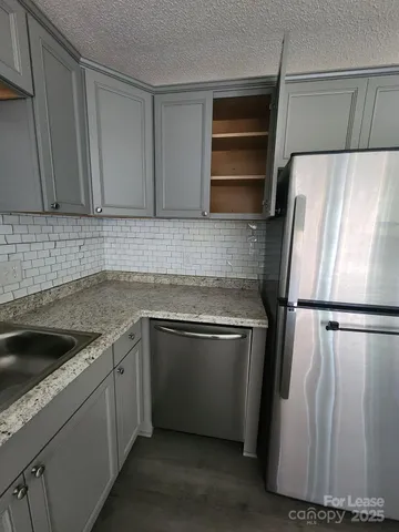 a kitchen with a refrigerator sink and cabinets