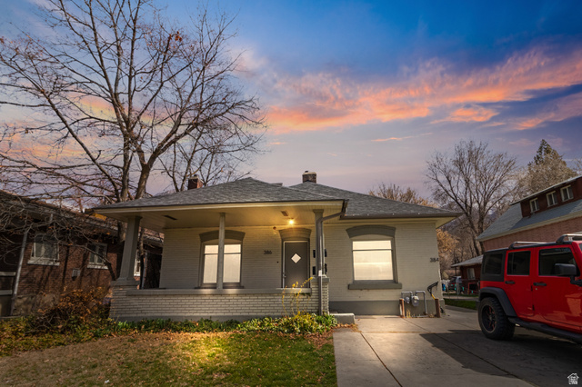 386 North 500 East Provo, UT 84606 - Photo 1 of 24 View of front of house with brick siding, covered porch, a chimney, and a yard