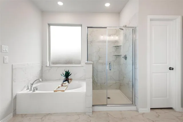 a white bath tub sitting next to a shower