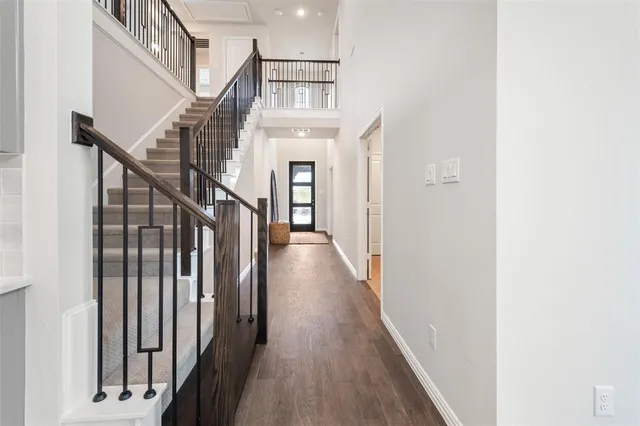 a view of a hallway with wooden floor and staircase