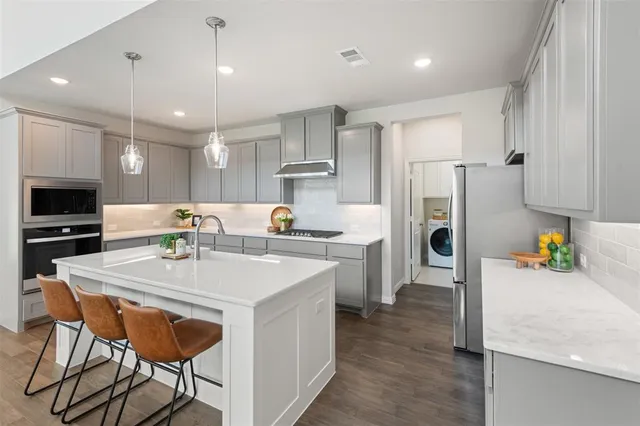 a kitchen with refrigerator and chairs