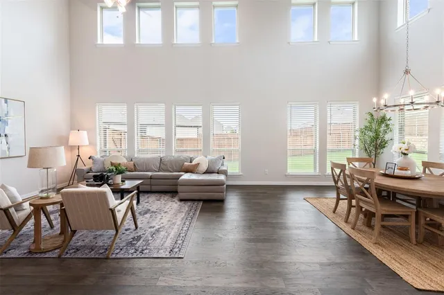 a living room with furniture wooden floor and a large window