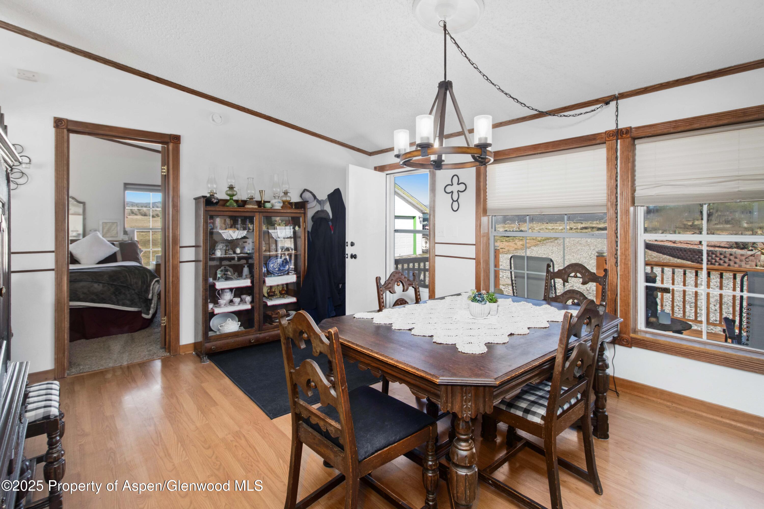 260 Lazy S Reverse Drive Silt, CO 81652 - Photo 16 of 30 a view of a dining room and livingroom with furniture wooden floor a rug a flat screen tv a rug and a chandelier