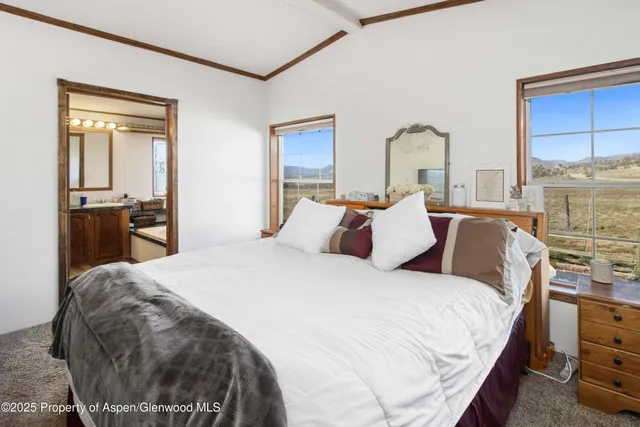 a large bed sitting in a bedroom next to a window