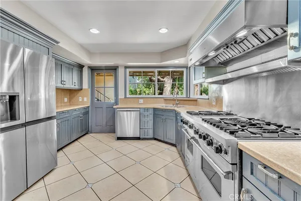 a kitchen with stainless steel appliances a stove a sink and a refrigerator