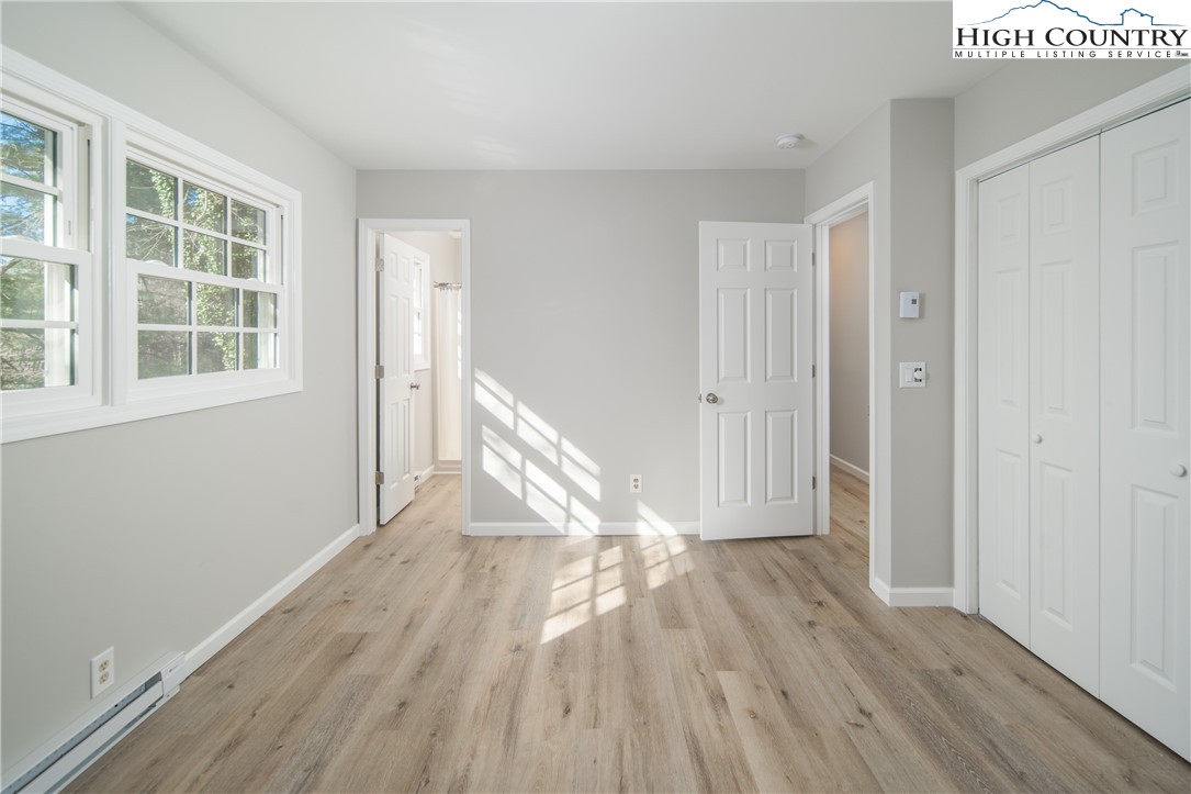 553 Hardaman Circle Boone, NC 28607 - Photo 12 of 42 an empty room with wooden floor and windows