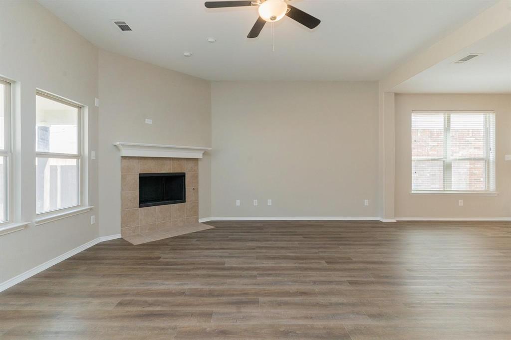 4313 Summer Star Lane Fort Worth, TX 76244 - Photo 12 of 26 Unfurnished living room with ceiling fan, a fireplace, and wood finished floors