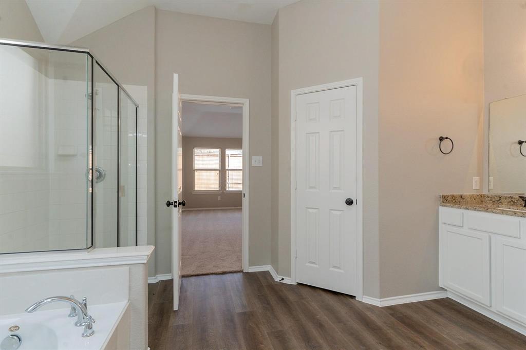 4313 Summer Star Lane Fort Worth, TX 76244 - Photo 17 of 26 Full bathroom featuring wood finished floors, vanity, a tub with jets, and an enclosed shower
