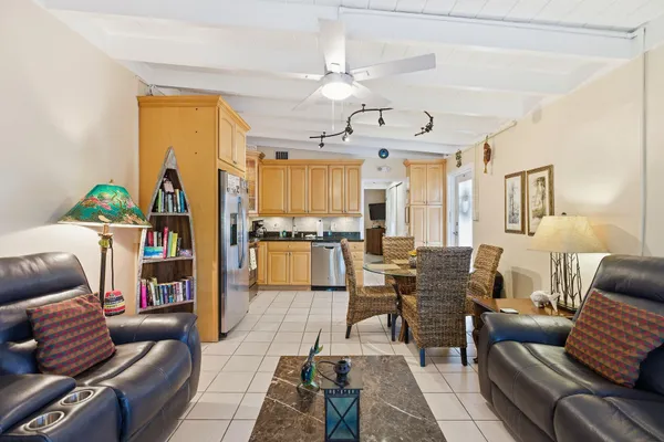 a living room with furniture kitchen view and a chandelier