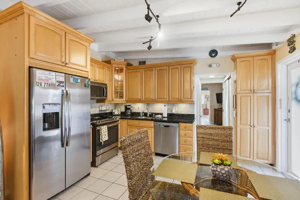 a kitchen with stainless steel appliances granite countertop a refrigerator a stove top oven a sink and dishwasher