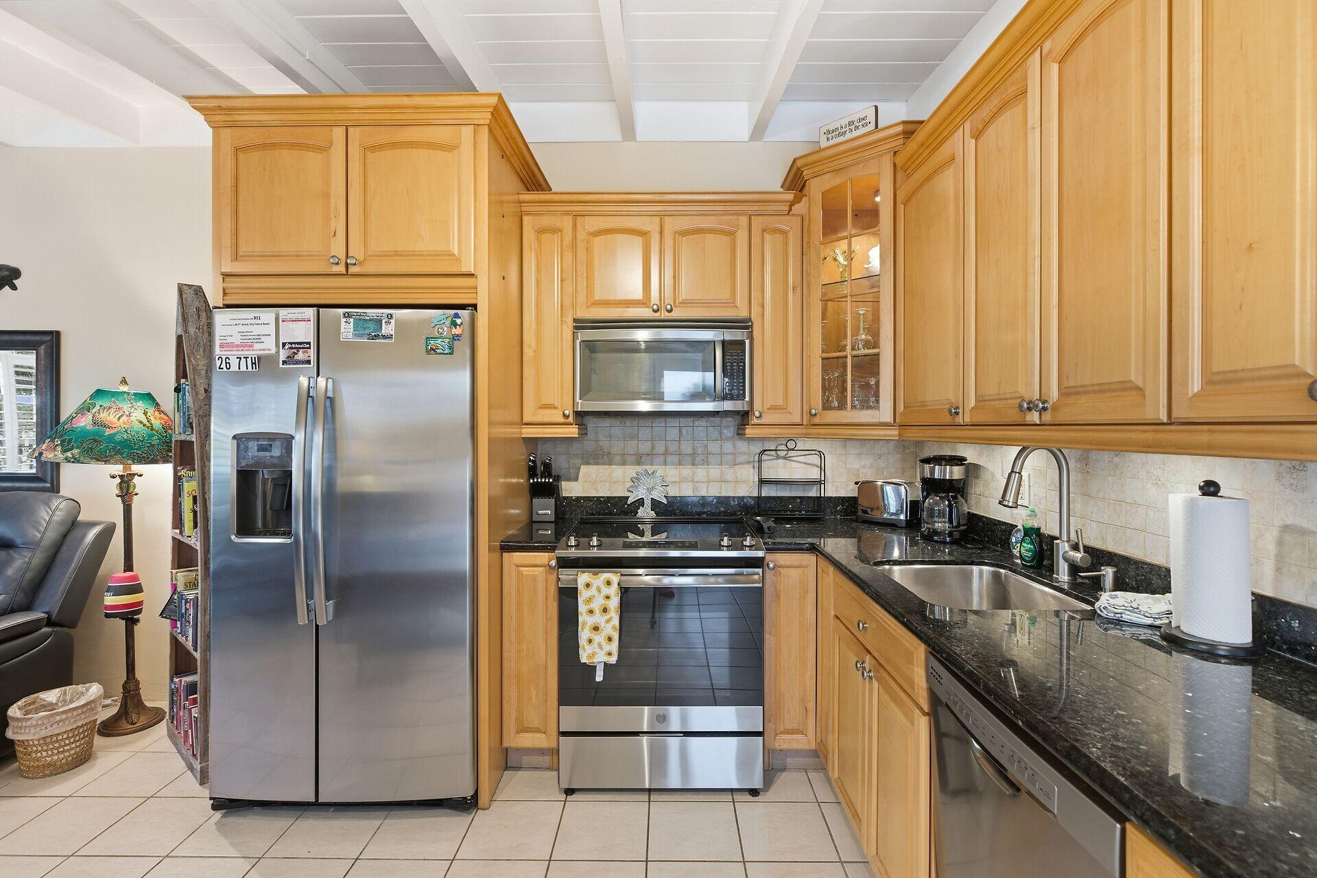 26 7th Street Key Colony Beach, FL 33051 - Photo 14 of 37 a kitchen with stainless steel appliances granite countertop a stove a sink and a refrigerator